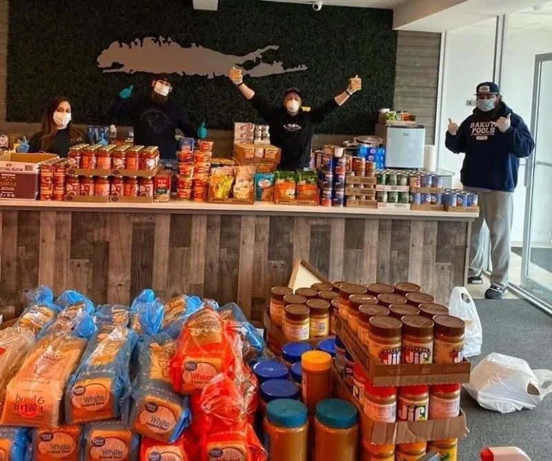 The four friends behind the free market, arms raised, in the East Neck office
